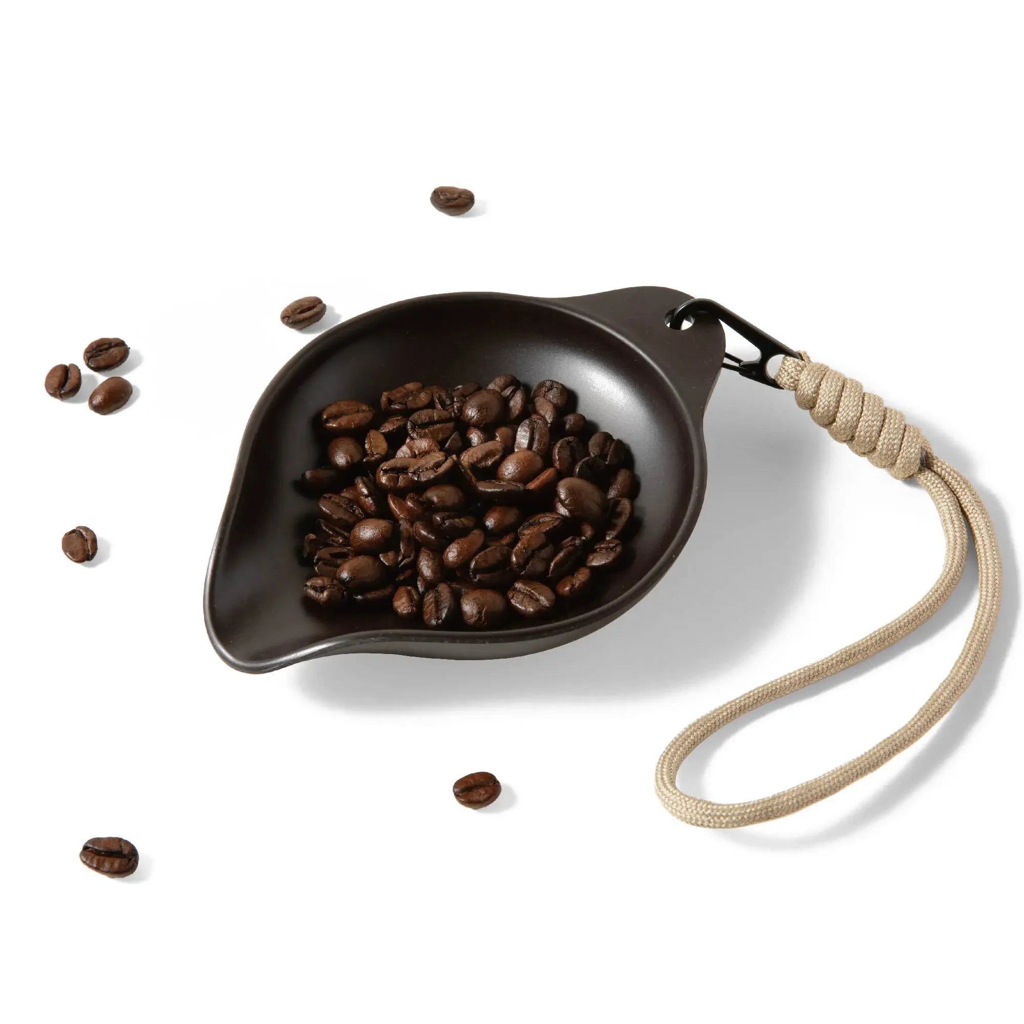 OutIn Rebrew Bean Tray with coffee beans, featuring a braided lanyard for portability. Made from recycled coffee grounds.