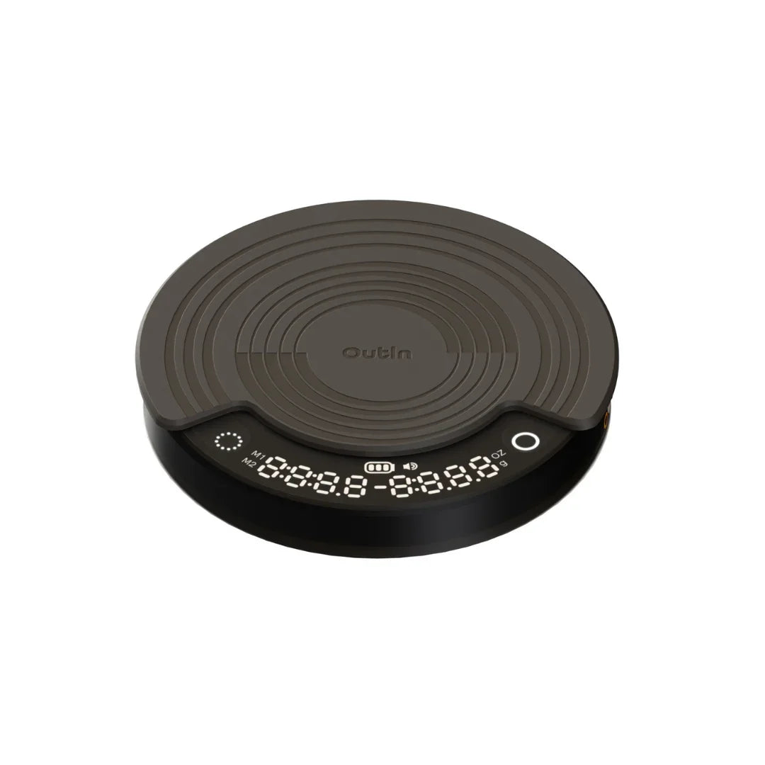 OutIn Claro coffee scale, round, dark gray, with silicone mat and digital display for time, weight, and brewing modes.