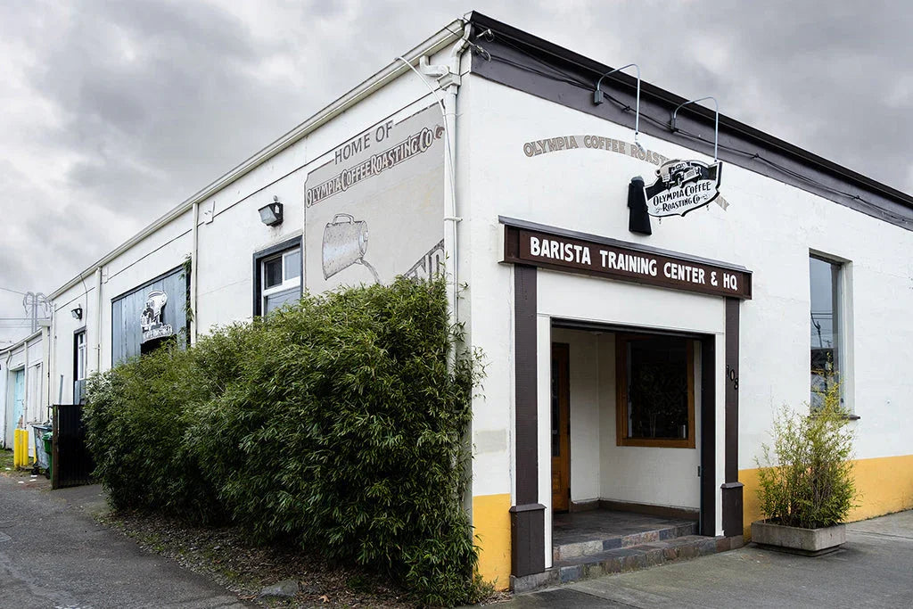 Olympia Coffee Roasting Company building exterior with 'BARISTA TRAINING CENTER & HQ' sign.
