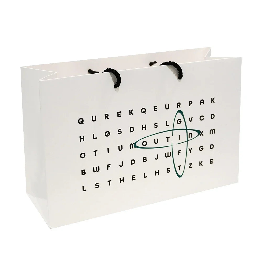 White gift bag, word search pattern, black rope handles, MOUTINX logo. Perfect for portable espresso machines.