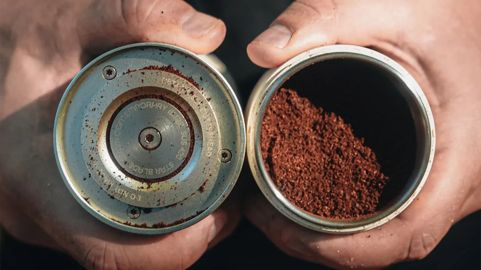 Close-up of manual coffee grinder parts with freshly ground coffee in hand, highlighting burr design and grind consistency.
