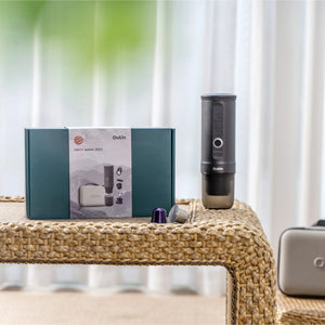 Space Grey OutIn Traveler Espresso Maker gift set with reddot winner 2023 packaging and protective case on table.