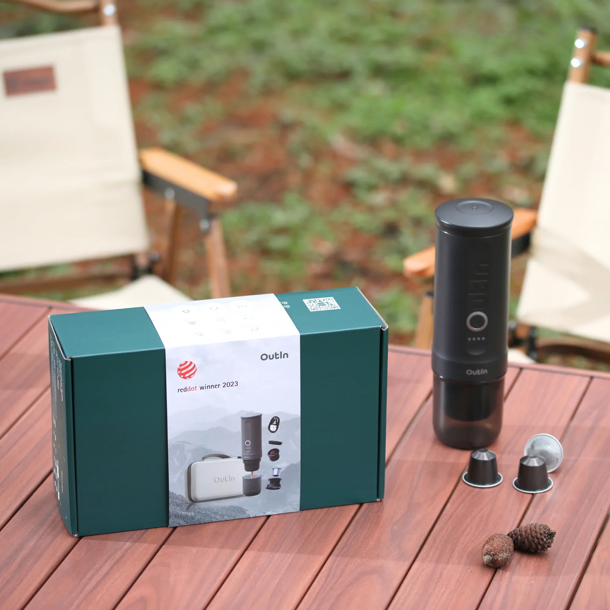 OutIn Traveler espresso maker gift set: Space Grey, with capsules, displayed in an outdoor camping setup.