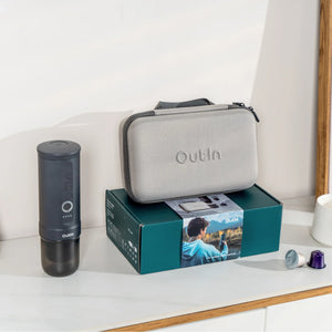 Space Grey OutIn Traveler Espresso Maker gift set with case and two coffee capsules on teal box.