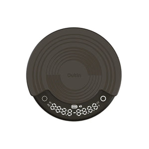 OutIn Claro coffee scale in dark gray, round design with concentric texture, showing timer, weight, and brewing modes M1/M2.