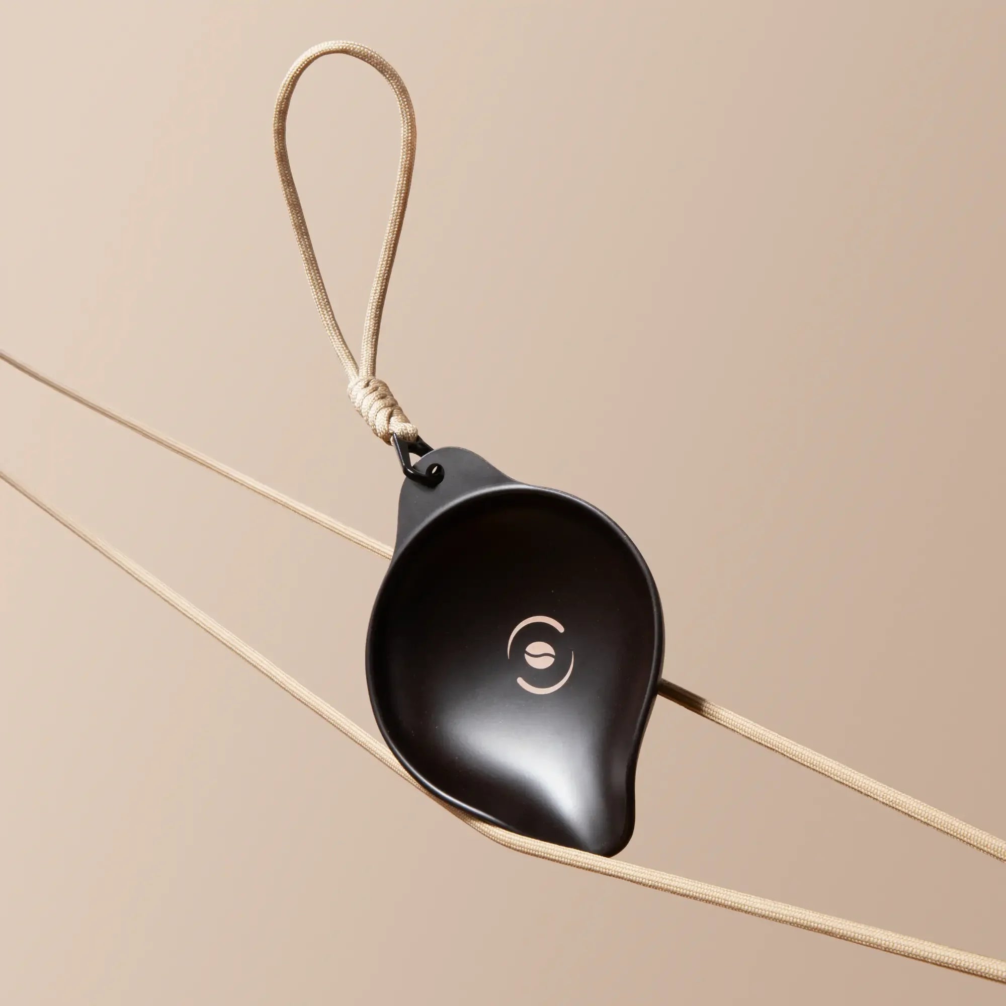 OutIn Rebrew Bean Tray, dark matte, drop-shaped with coffee bean logo and braided lanyard for portability.
