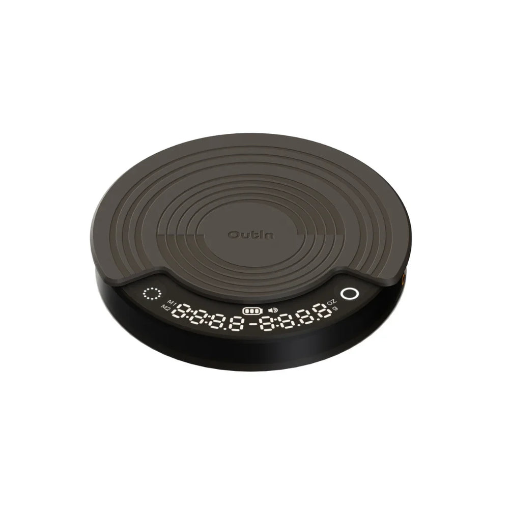 OutIn Claro coffee scale, round, dark gray, with silicone mat and digital display for time, weight, and brewing modes.