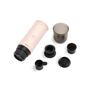 Rose Quartz Nano portable espresso machine with coffee grounds basket, scoop, and capsule adapter.