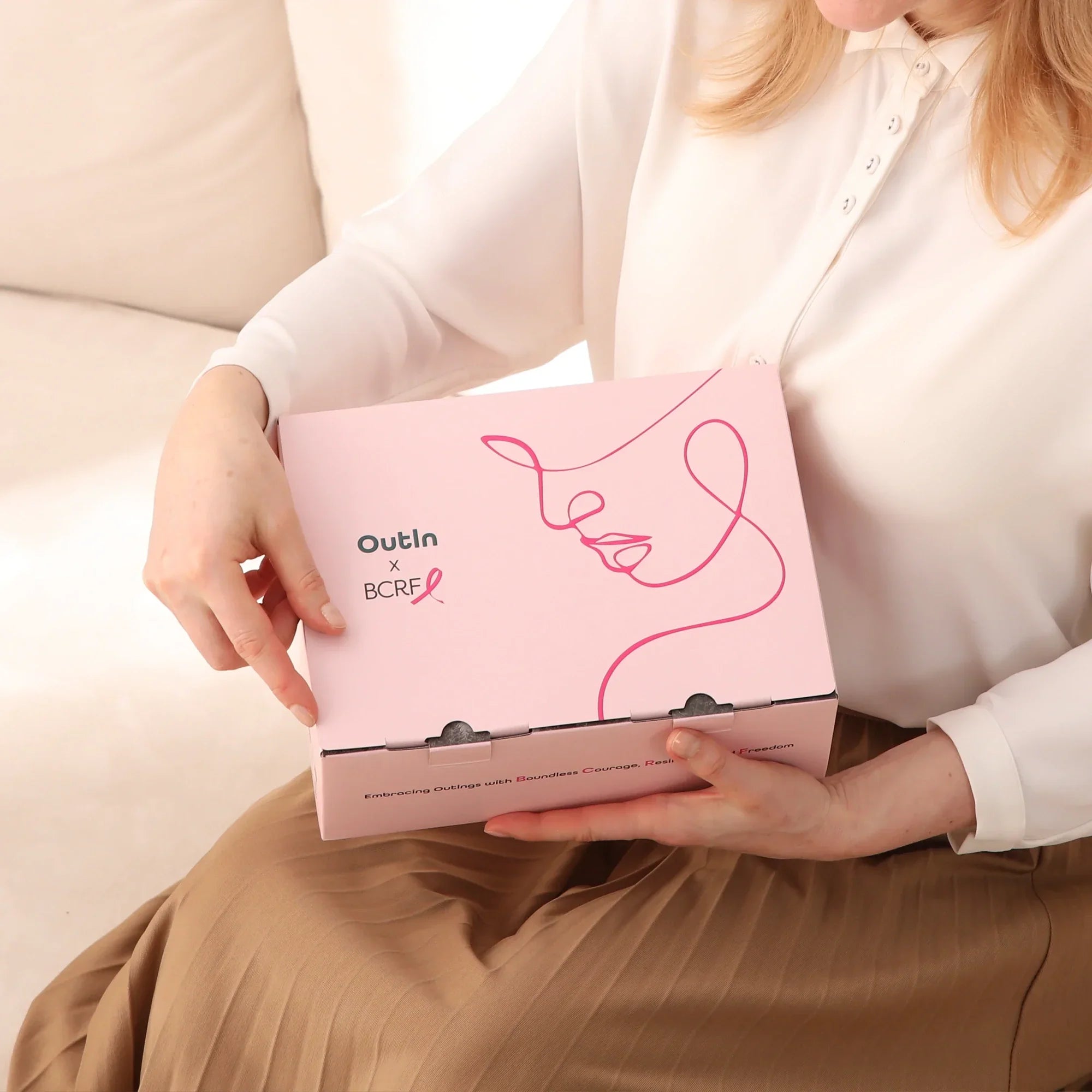 Woman holds pink Nano Portable Espresso Machine Rose Quartz X BCRF box with OutIn x BCRF branding.