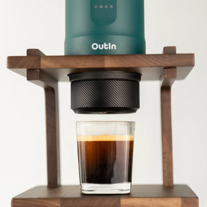 Teal OutIn Nano portable espresso machine brewing double espresso into glass with 16-18g basket.