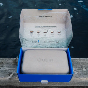 OutIn Nano portable espresso machine travel case in open retail packaging with brewing recipes inside lid.