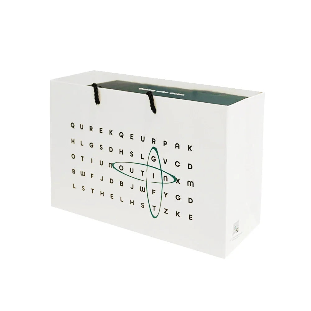 White gift bag with word search design and black rope handles, perfect for a portable espresso machine or travel items.