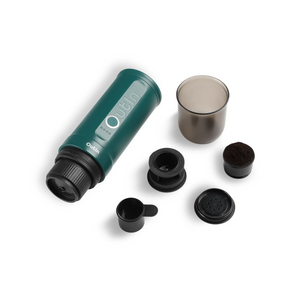 OutIn Nano teal portable espresso machine with brewing cup, capsule adapter, scoop, and ground coffee for versatile brewing.