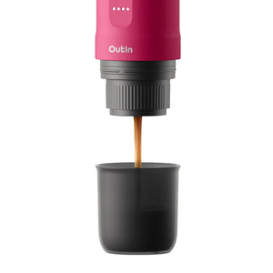 Fuchsia Nano portable espresso machine brewing rich espresso into a dark grey cup, showcasing brewing process.