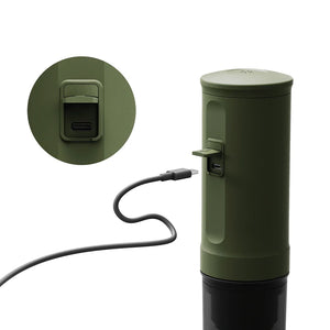Forest green OutIn Nano portable espresso machine charging via USB-C cable, showing port detail.