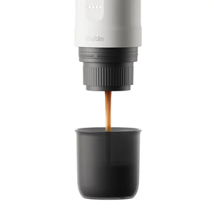Pearl white Nano portable espresso machine brewing rich espresso with crema into a cup.