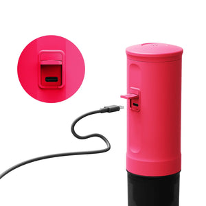 Fuchsia Nano portable espresso machine charging via USB-C cable, showcasing the charging port detail.