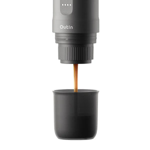 OutIn Nano portable espresso machine in Space Grey brewing fresh espresso into a dark grey cup.